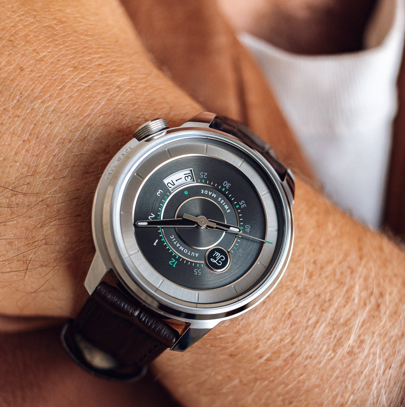 Close-up of a wrist wearing a Tate Wade Stainless Steel with a brown leather strap.